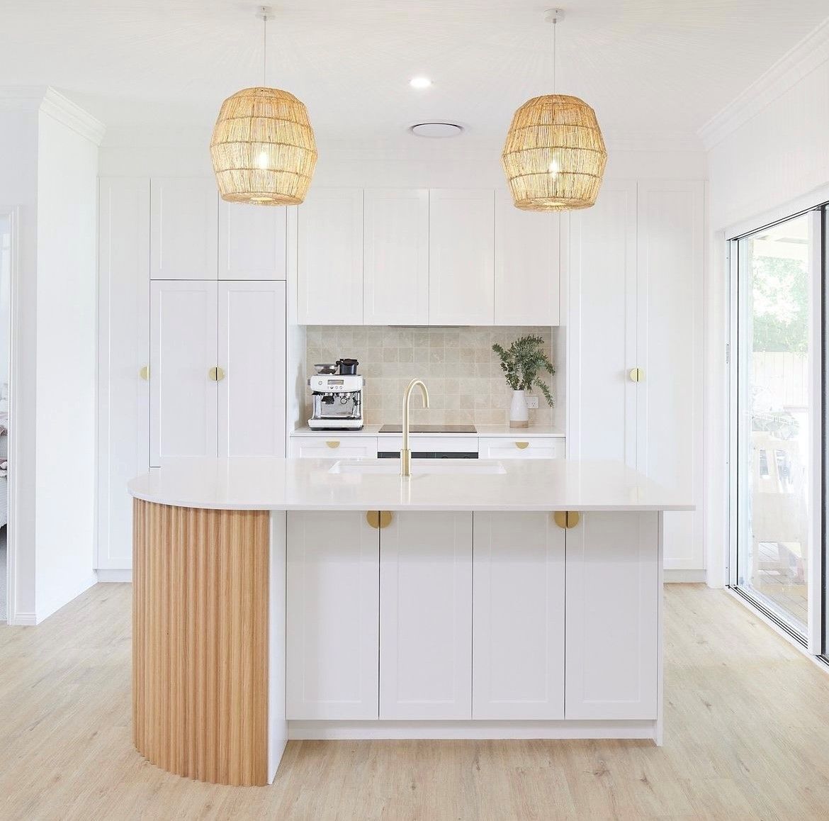 Bright white kitchen with wooden island, pendant lights, and gold hardware — Tile Trends in Tweed Heads South, NSW
