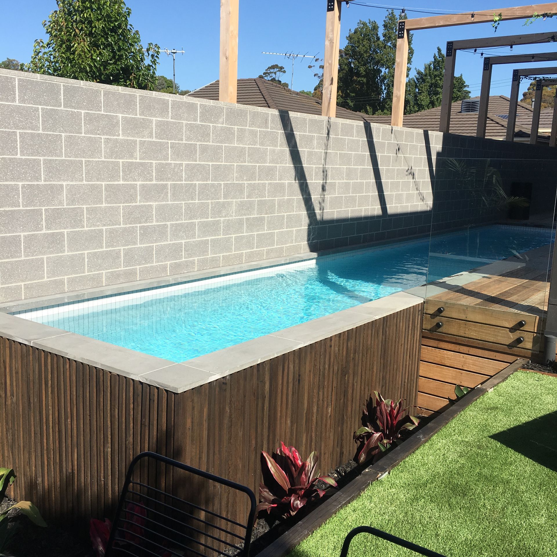 Swimming Pool With White Tiles And Grey Brick Wall Surrounded It — Tile Trends in Ballina, NSW