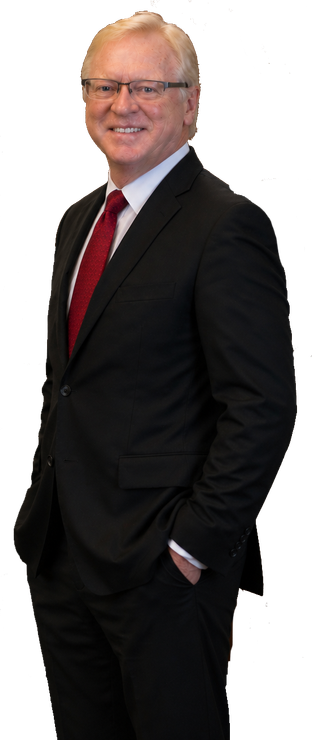 Smiling man in a black suit with a red tie, standing against a white background