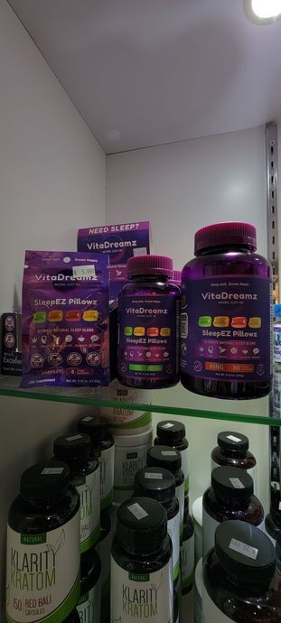 Shelves displaying purple-labeled supplement bottles and boxes.