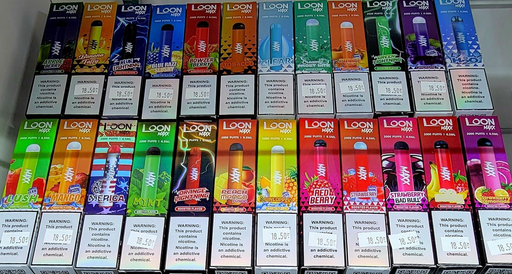Rows of colorful vape boxes on a shelf, displaying different flavors and designs.