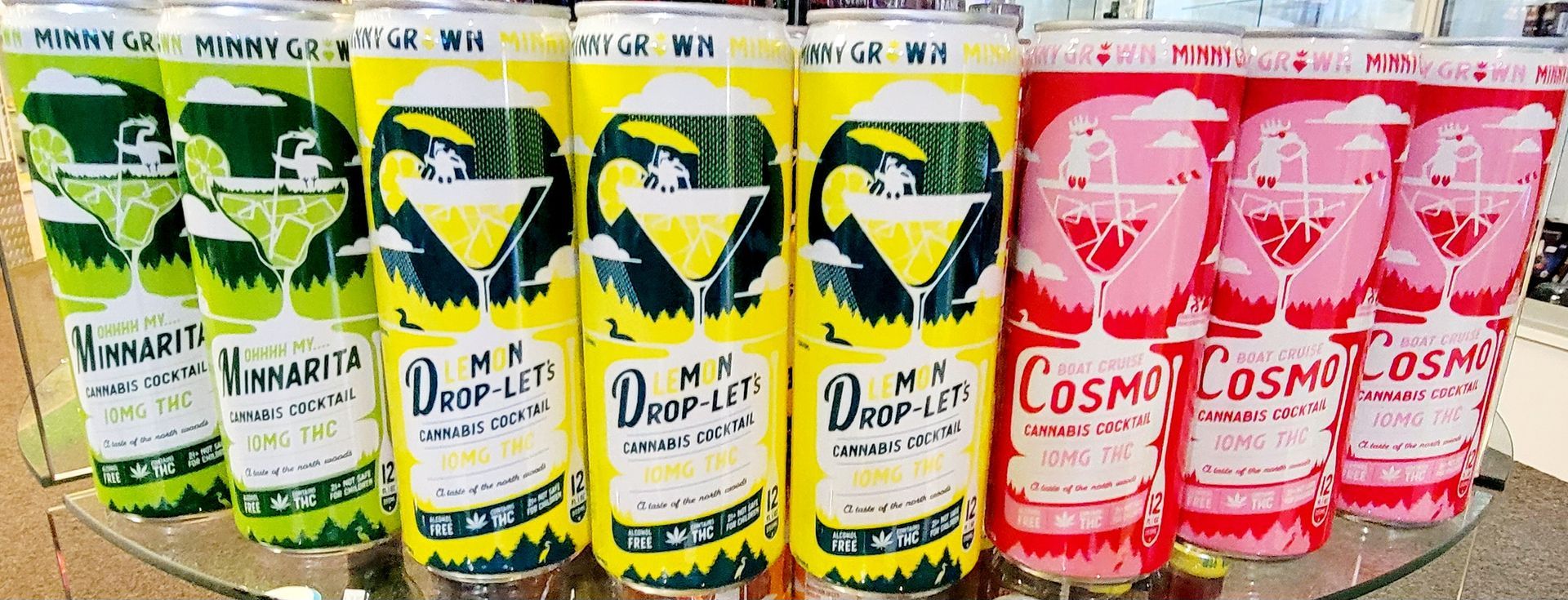 Cans of Margarita, Lemon Sour, and Cosmo alcoholic beverages, arranged in a row.