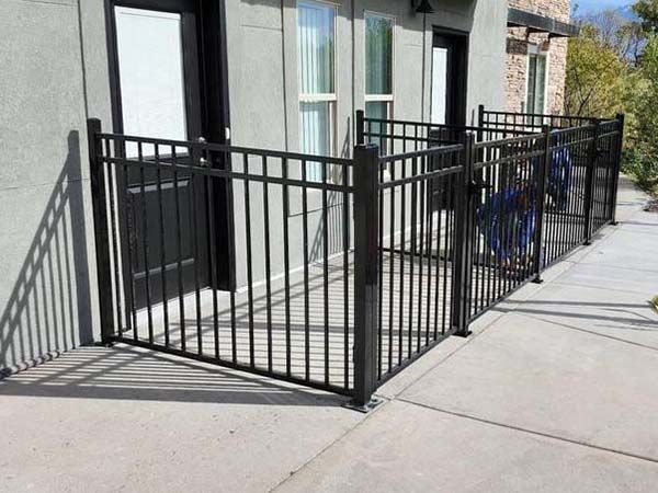 Black metal accessibility ramp with railings beside a building entrance on a sidewalk