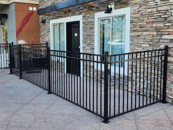 Black metal accessibility ramp and railings beside a stone building entrance