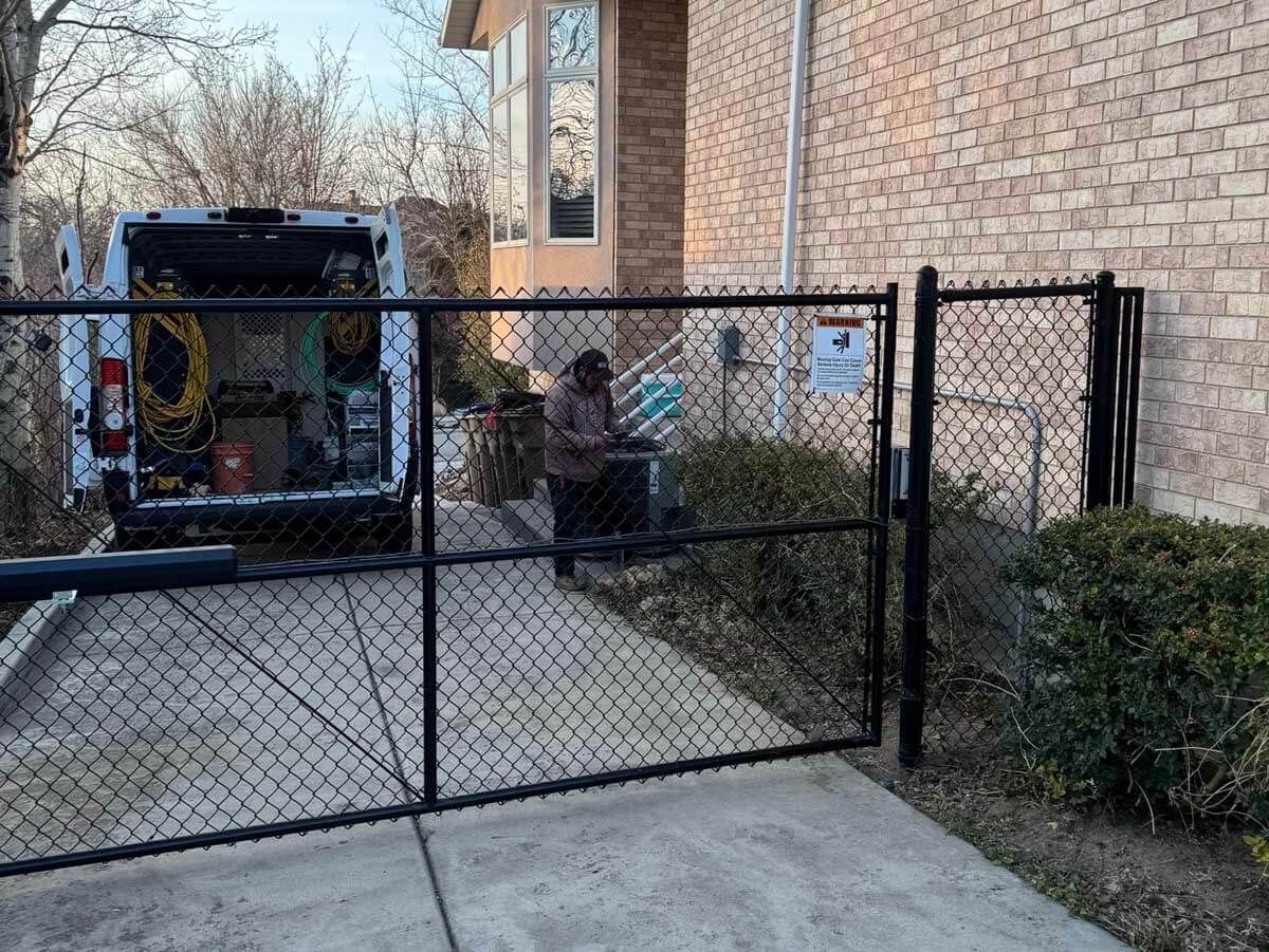 Chain-link fence with open gate and matching fence panels on either side