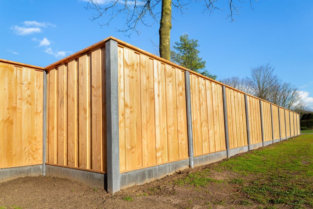 Wood-paneled outdoor fence panels with black metal posts forming a corner enclosure