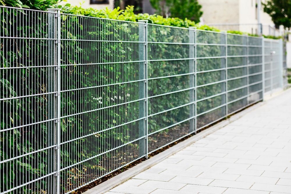 White woven fence with tan wooden posts forming an outdoor corner enclosure