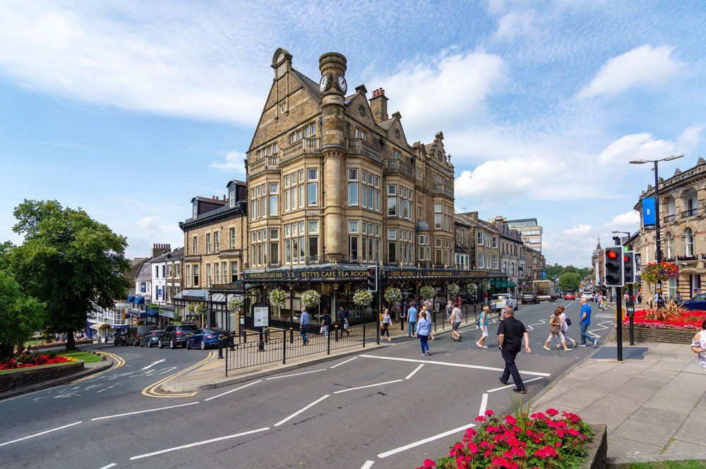 A city street with a large stone building on the corner of a street