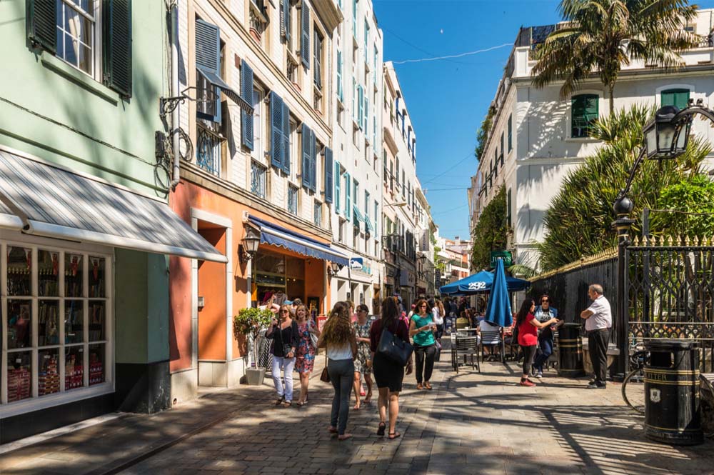 A sunny street scene with people browsing shops
