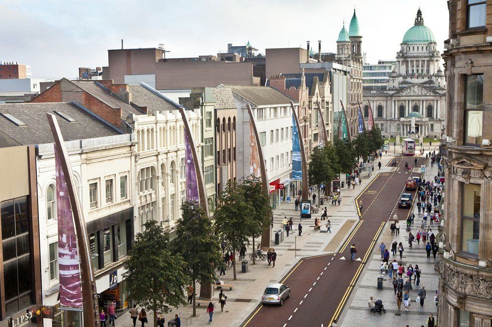 A high viewpoint of a city street with people walking on the pavemements