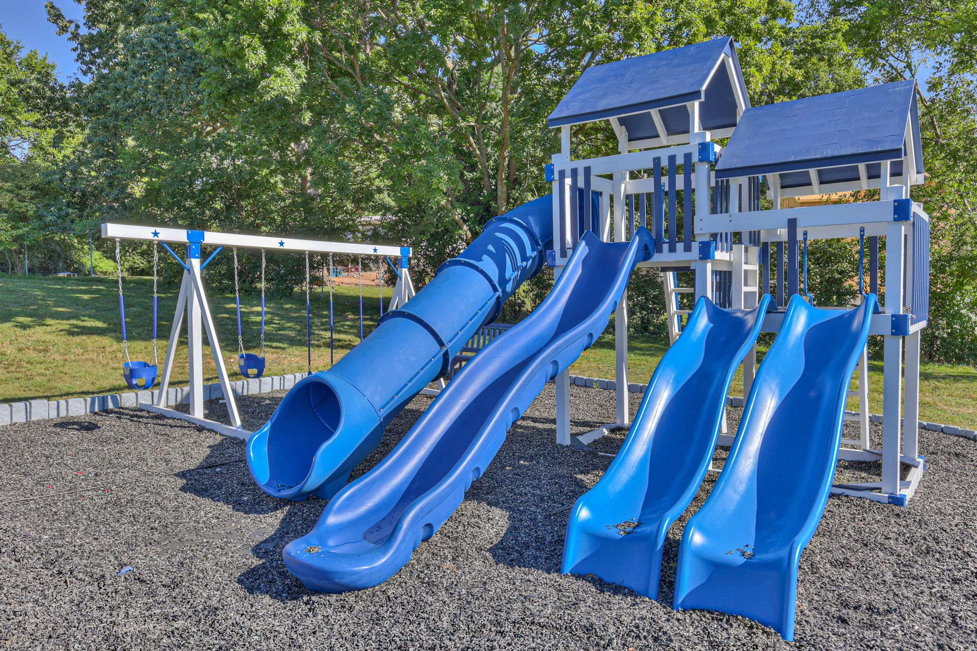 Photo of a playground showing four differrent slides, and other play equipment