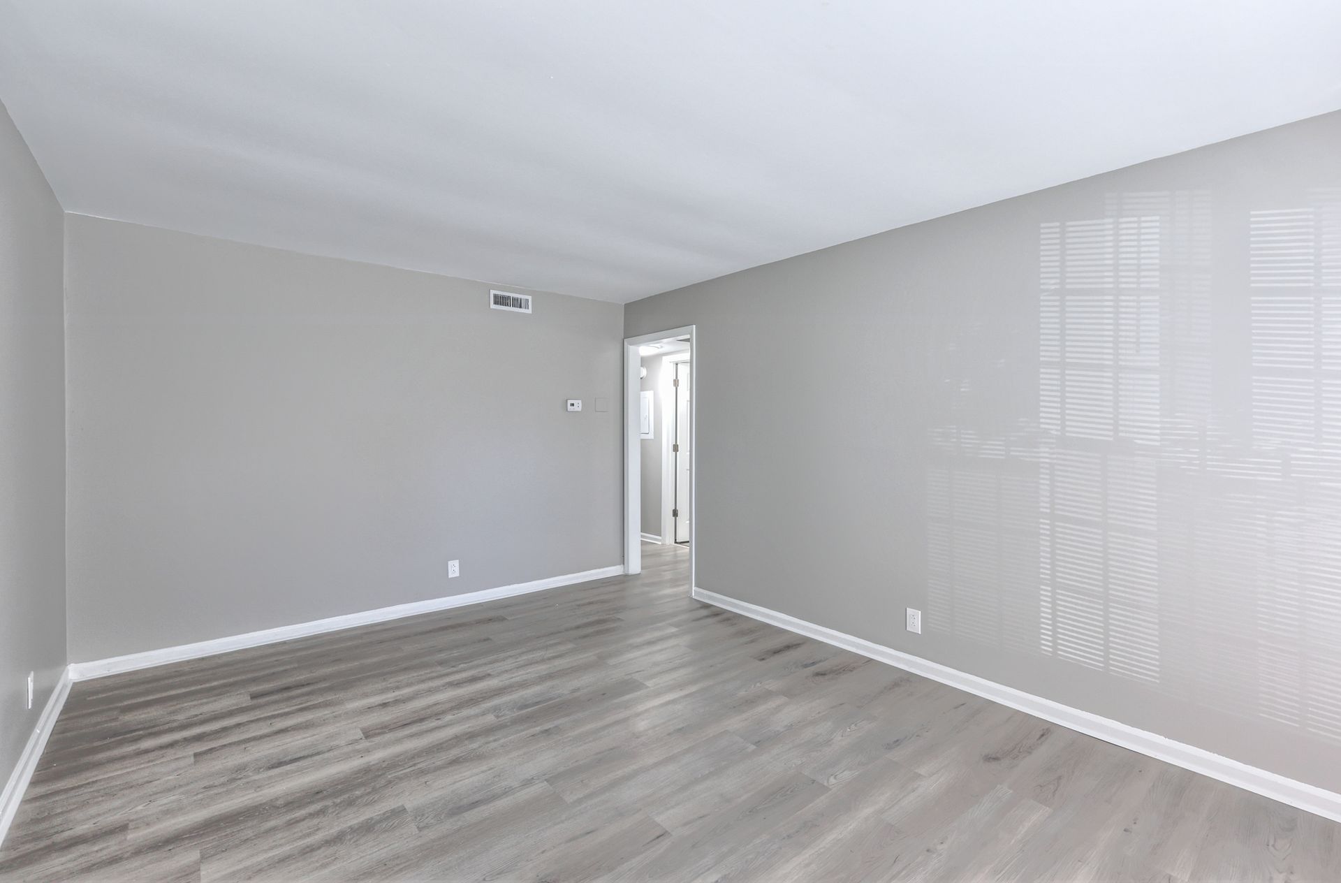 Photo of a living room with the hallway in the background