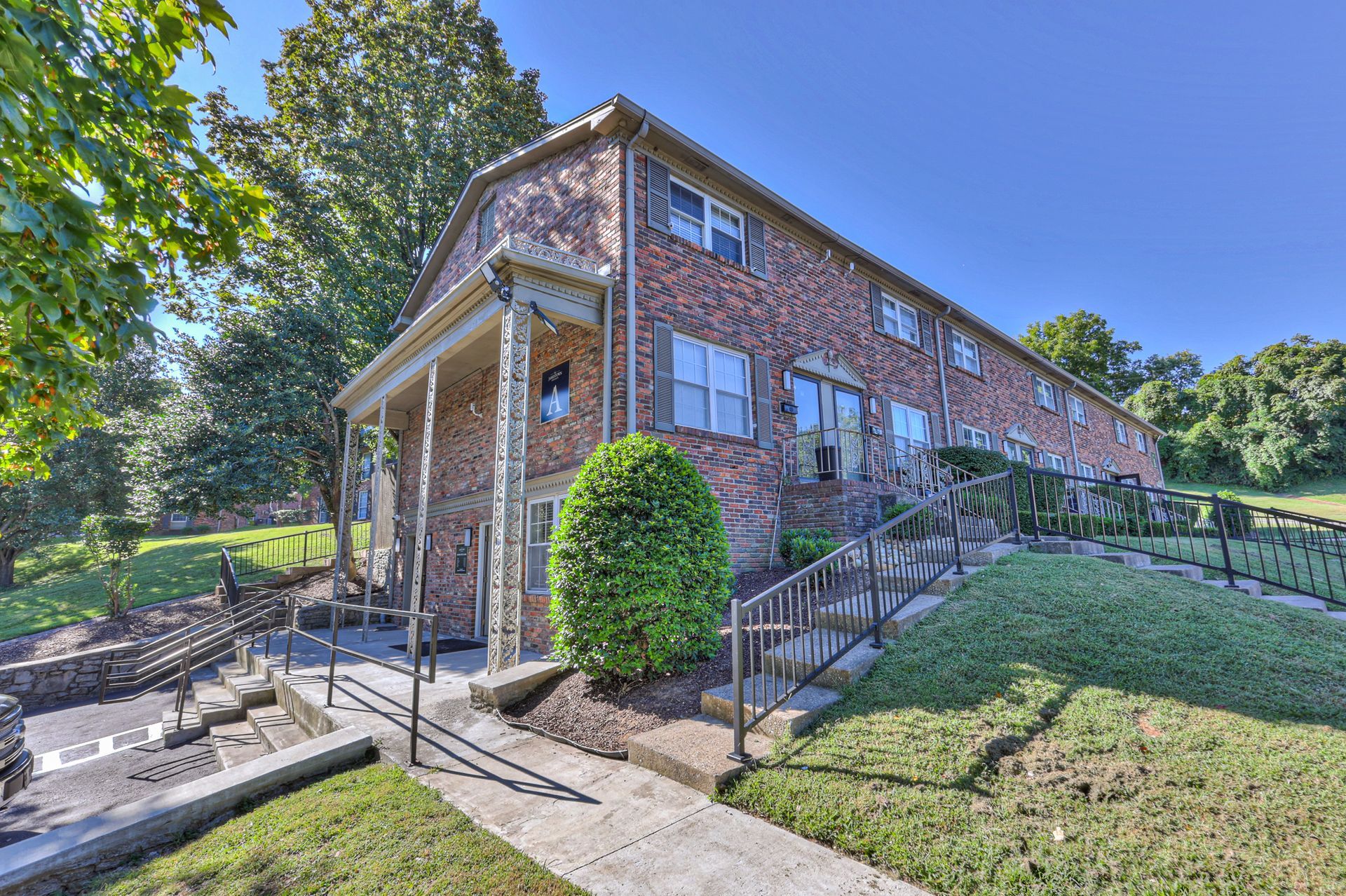 Photo of a multi-story building with a hill and stairs