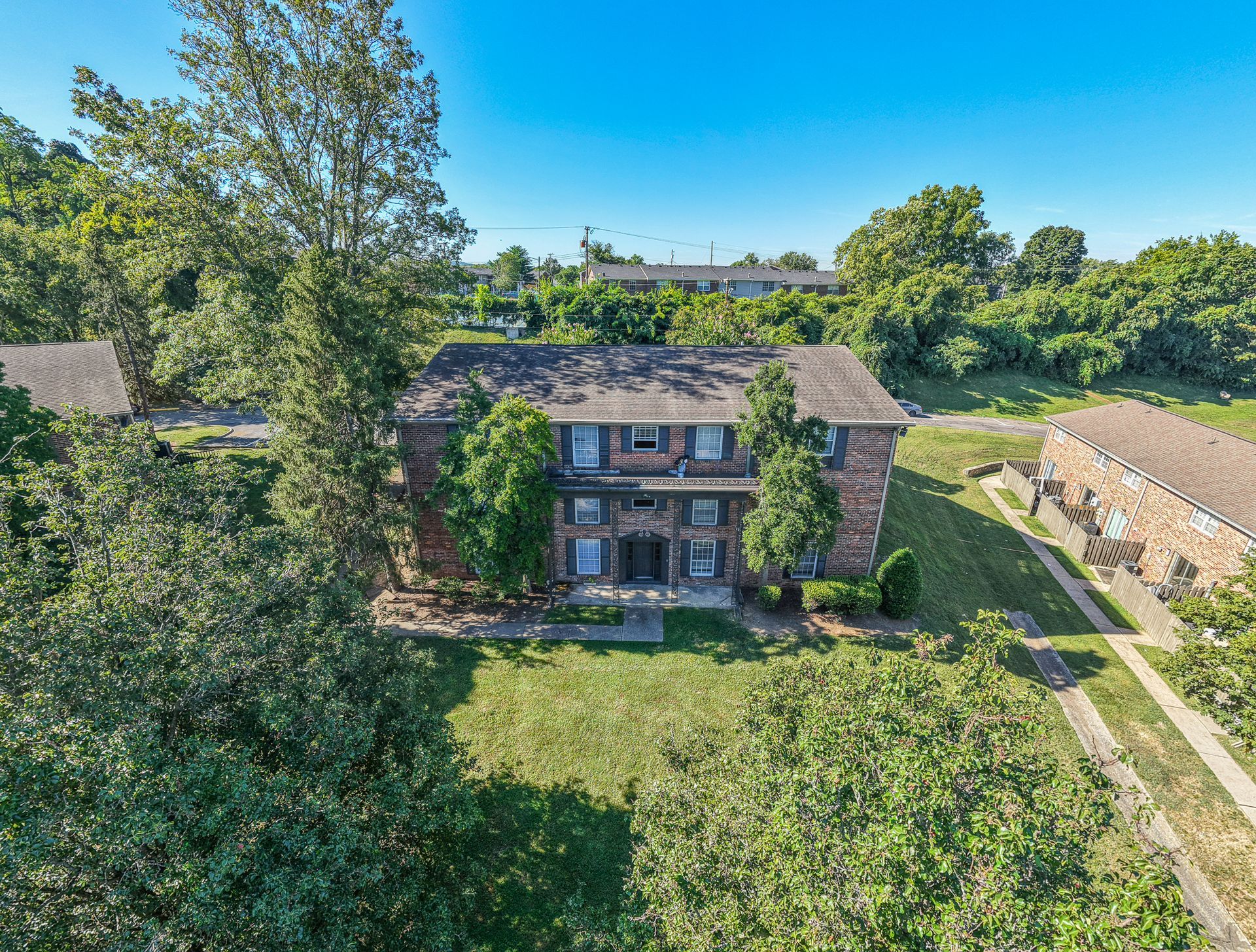 Photo of a three story bulding with plenty of greenery around