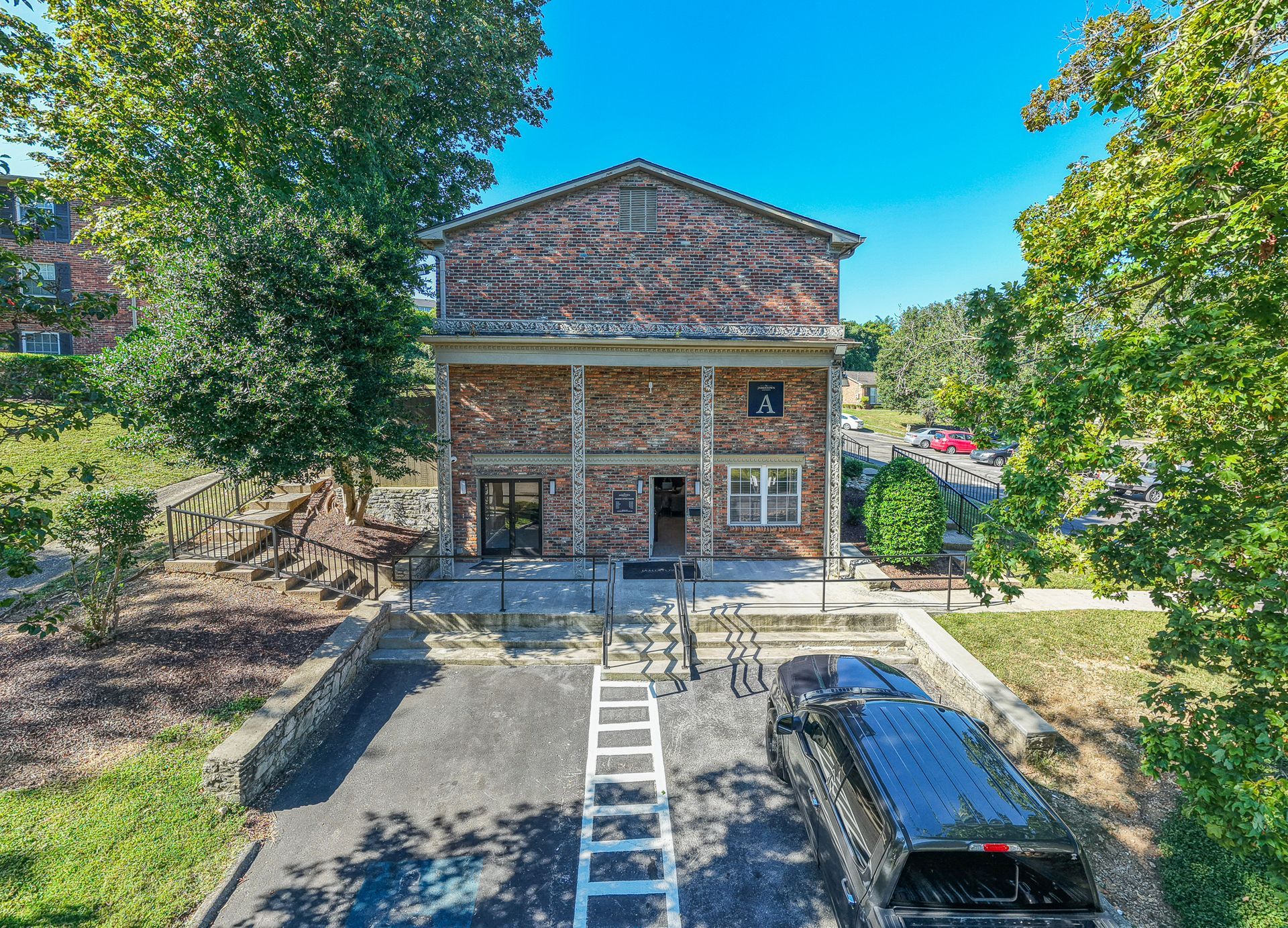 Photo of a three story building with a small parking space out front