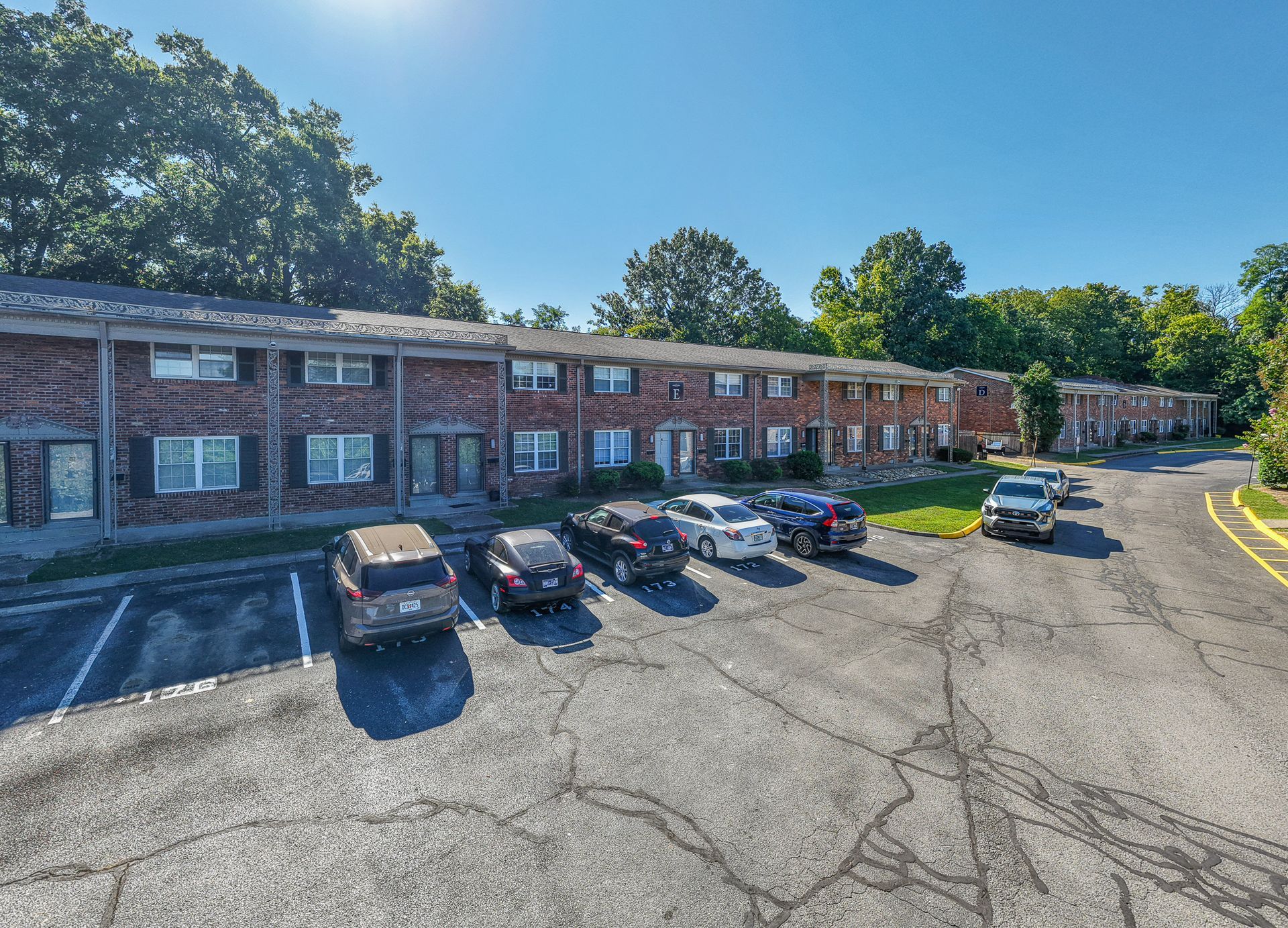 Photo of a two-story building with a parking lot out front and roadway to the parking lot