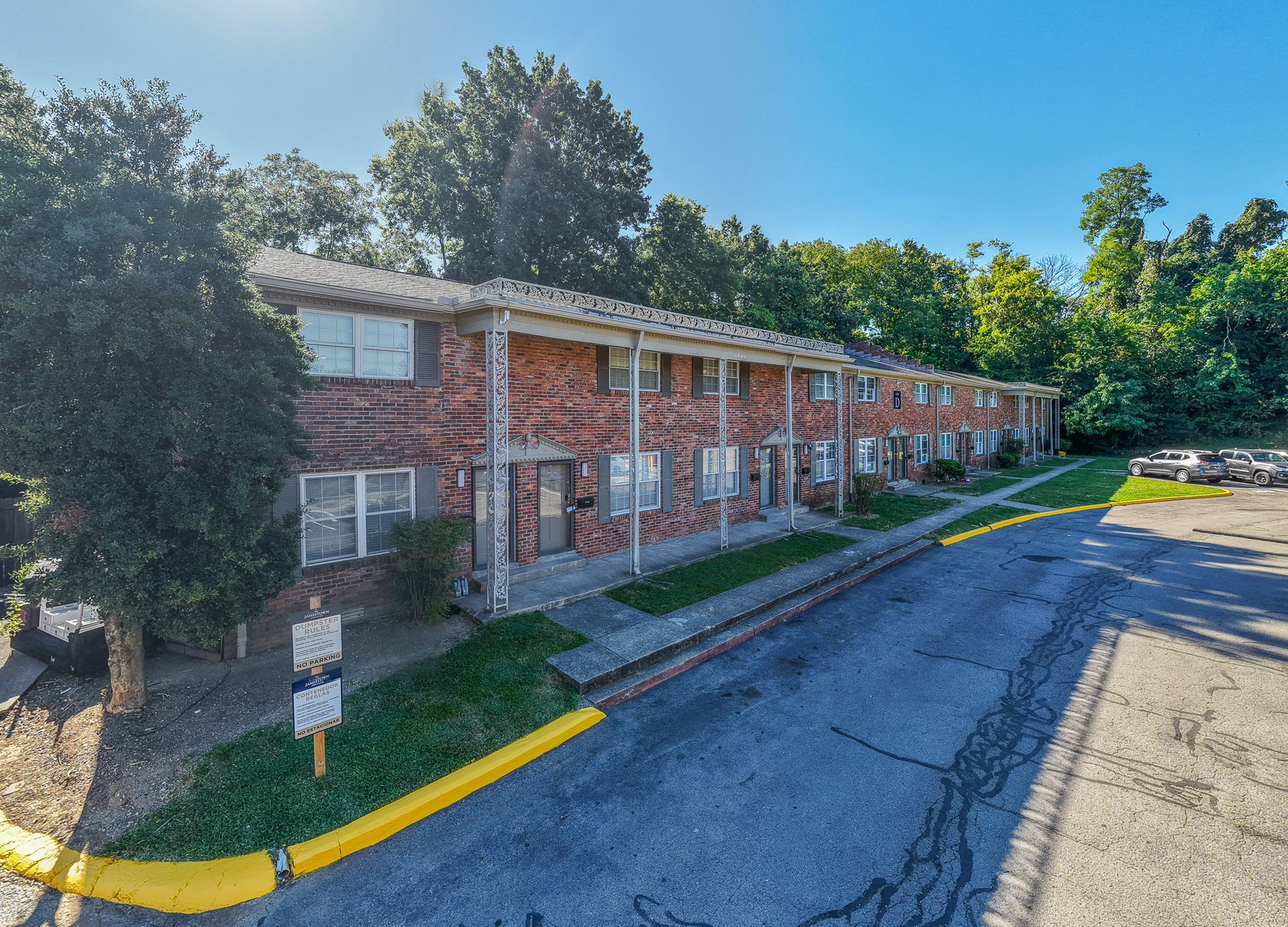 Photo of a building, two stories with red bricks and a parking lot out front