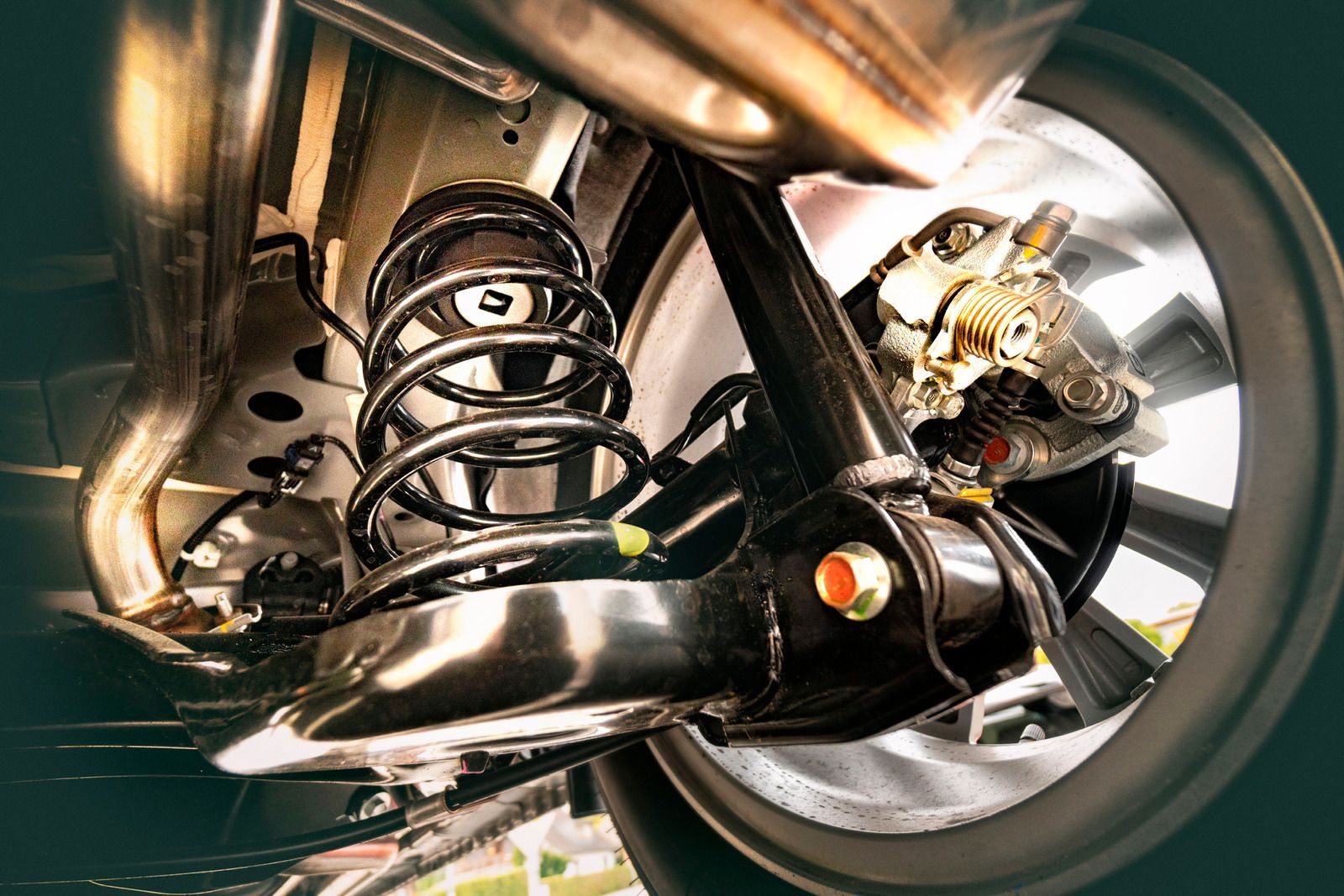 Car suspension system, including coil spring, shock absorber, and brake assembly, viewed from below.