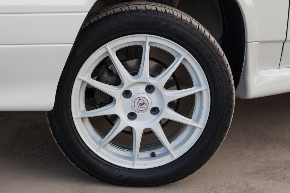 White car wheel with black tire.