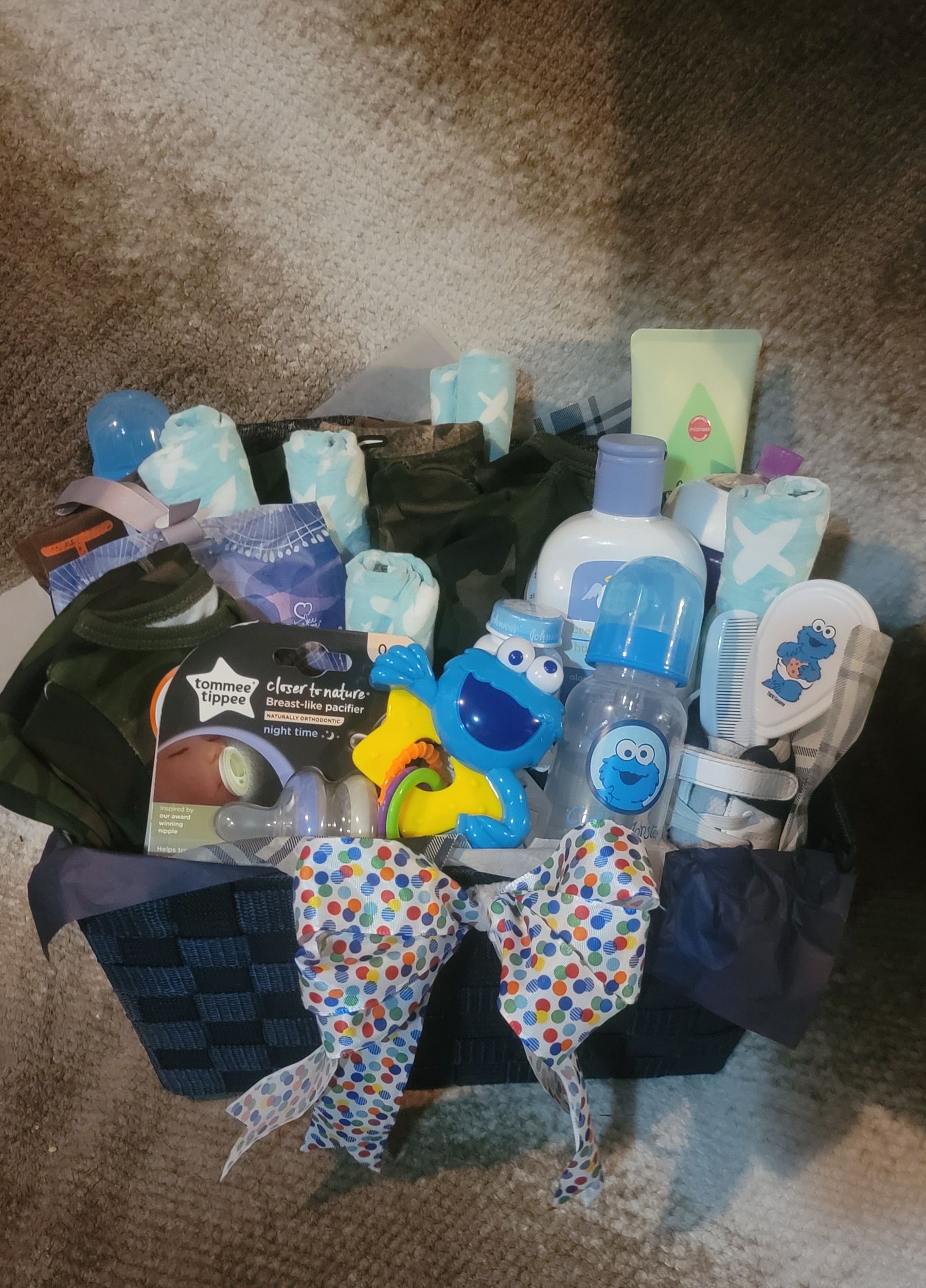 Gift bag of assorted baby care items, including diapers, lotions, wipes, and colorful decorations.