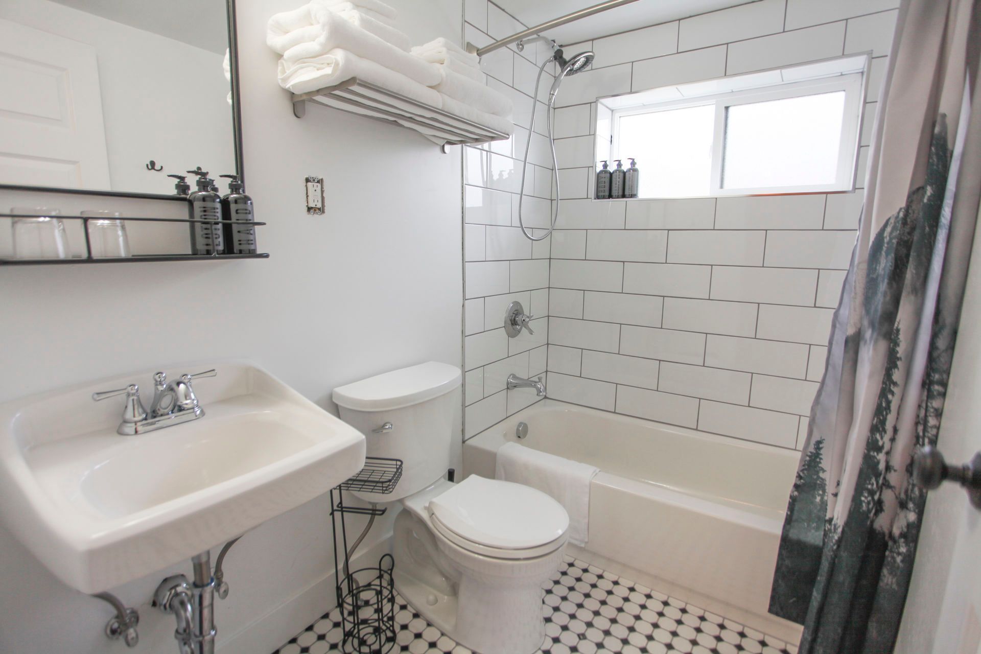 Bathroom with white subway tile, black and white floor, and a shower curtain.