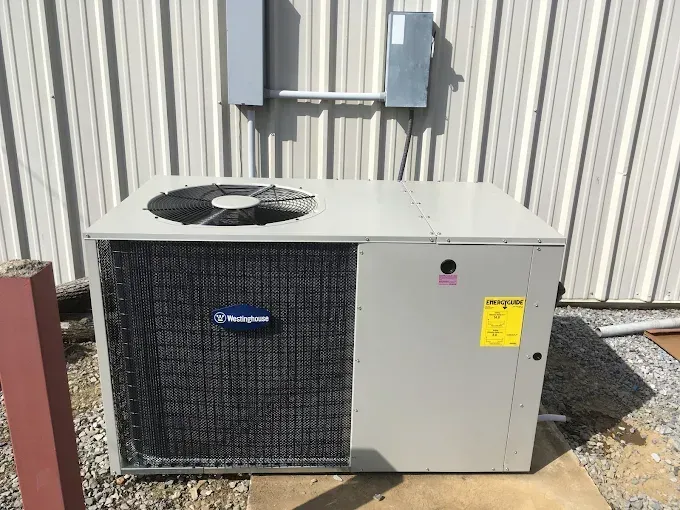 Outdoor Westinghouse air conditioning unit near a building with electrical boxes.