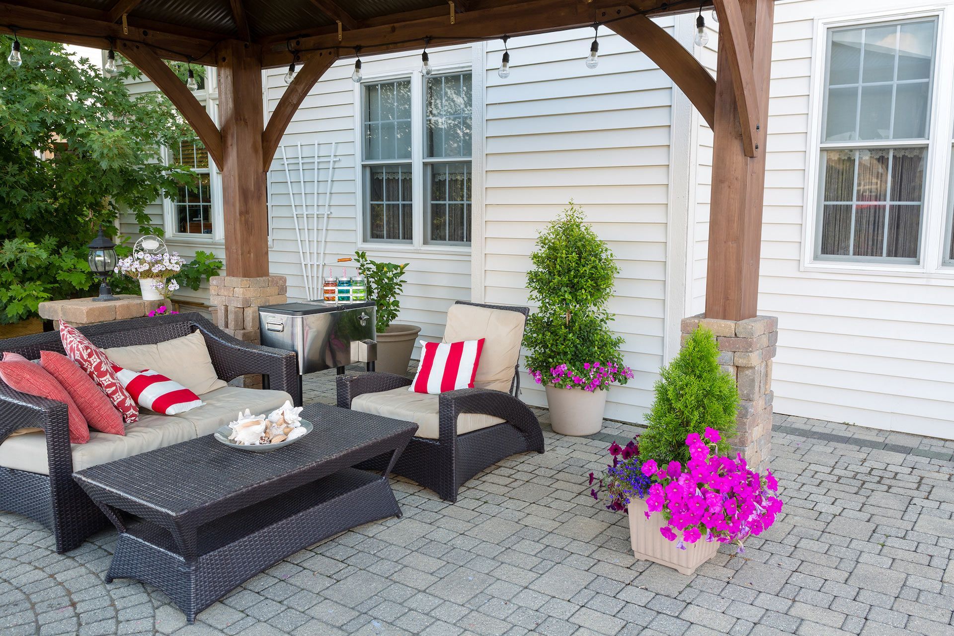 Custom paver patio with outdoor wicker furniture and colorful potted flowers for paver patio installation in West Melbourne FL