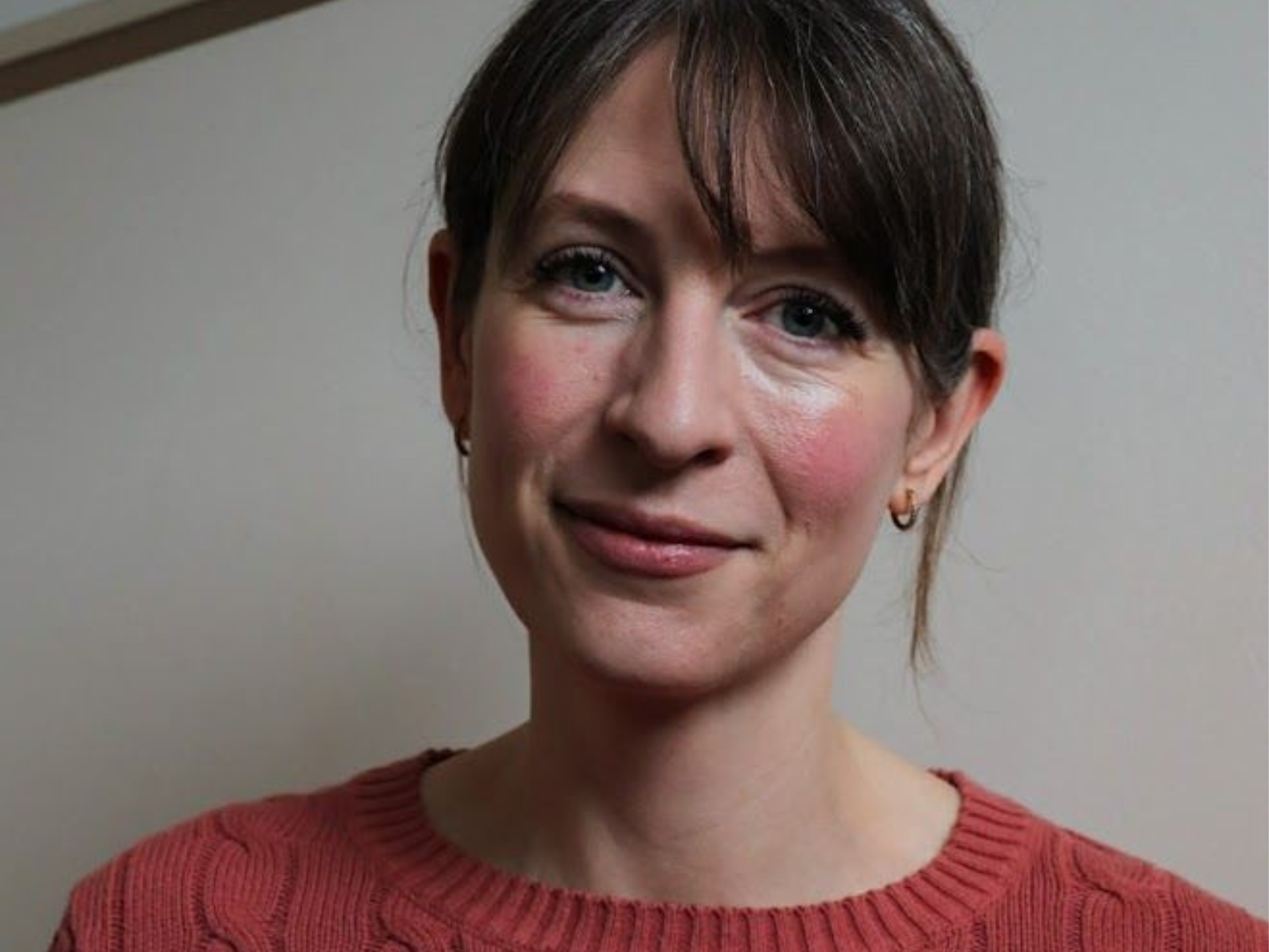 A woman is sitting in a chair and smiling at the camera.