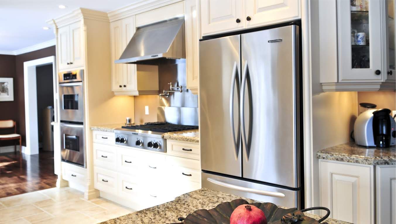 An elegant white kitchen cabinet with a built-in microwave oven on top of a kitchen stove.