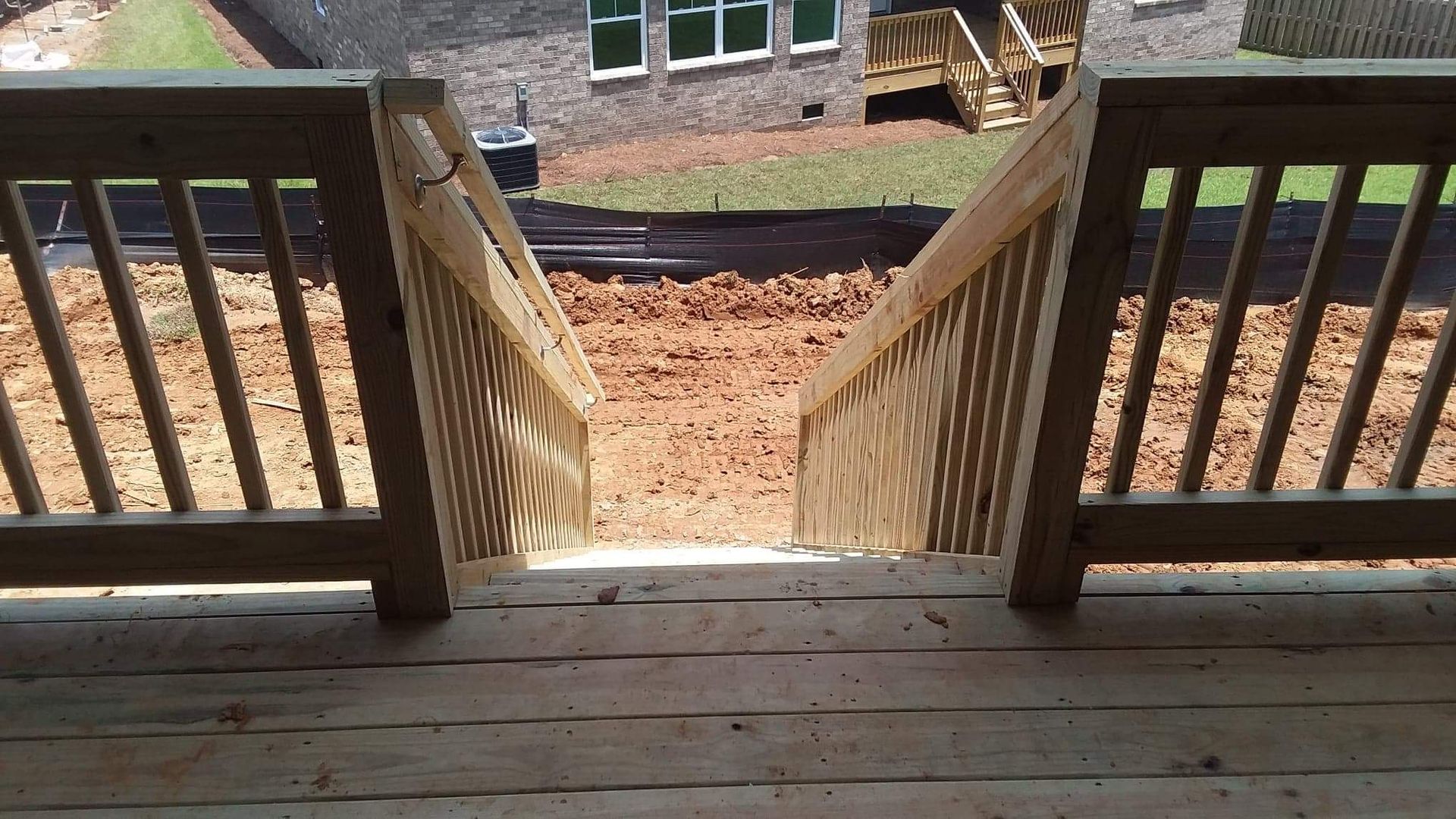 A wooden deck with stairs leading up to a house