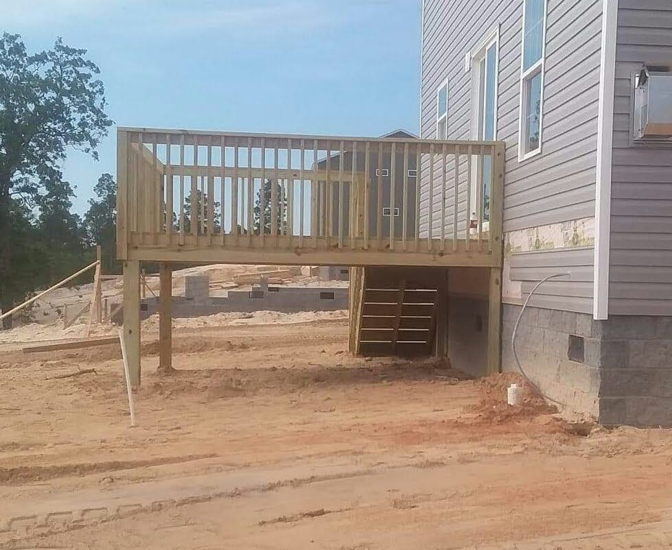 A wooden deck is being built in front of a house.