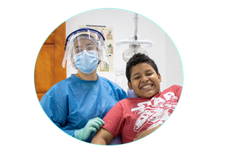 Paciente dental sonriendo con el clínico con traje protector azul y protector facial en una clínica.