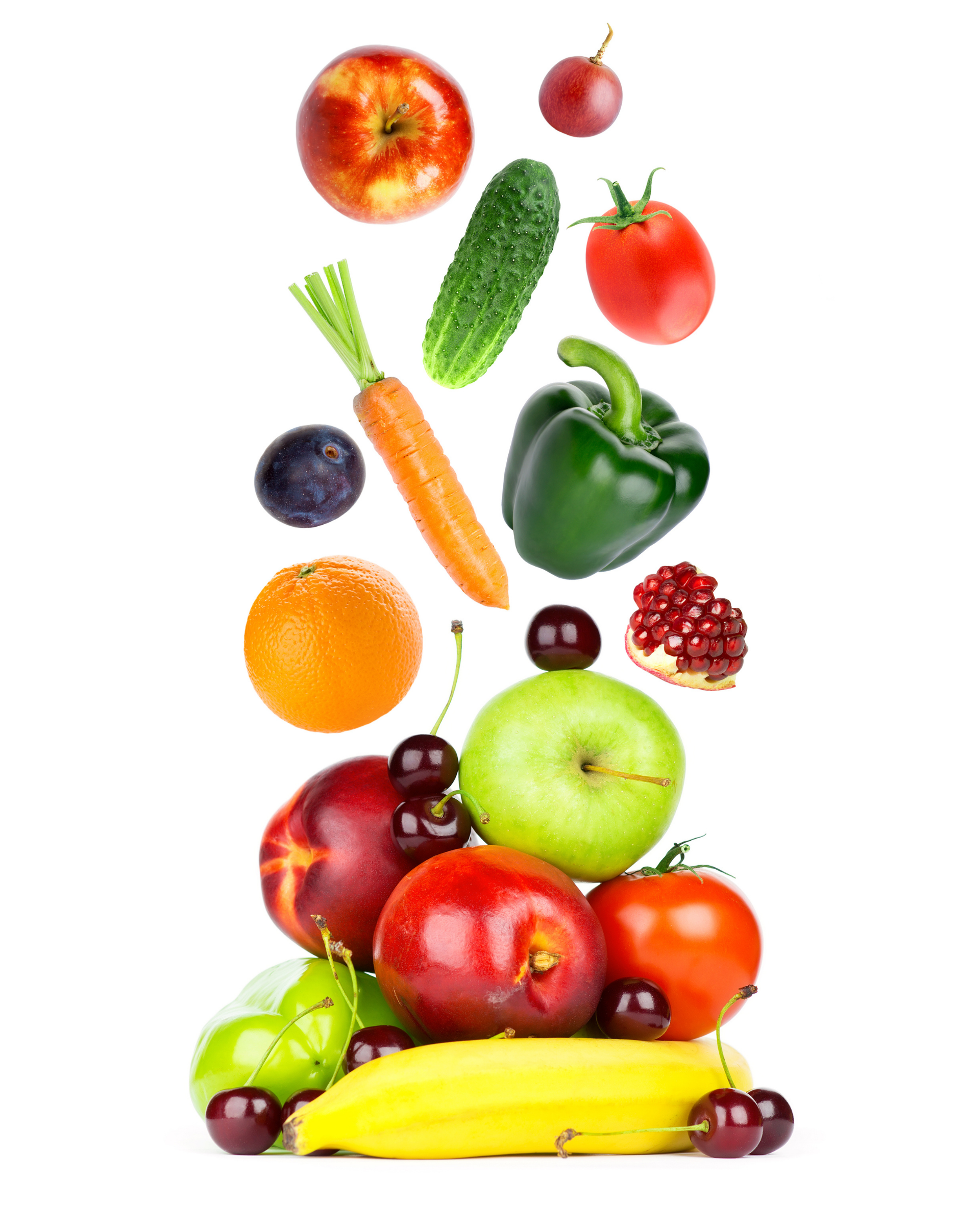 Assorted fruits and vegetables stacked in a colorful pyramid on a white background