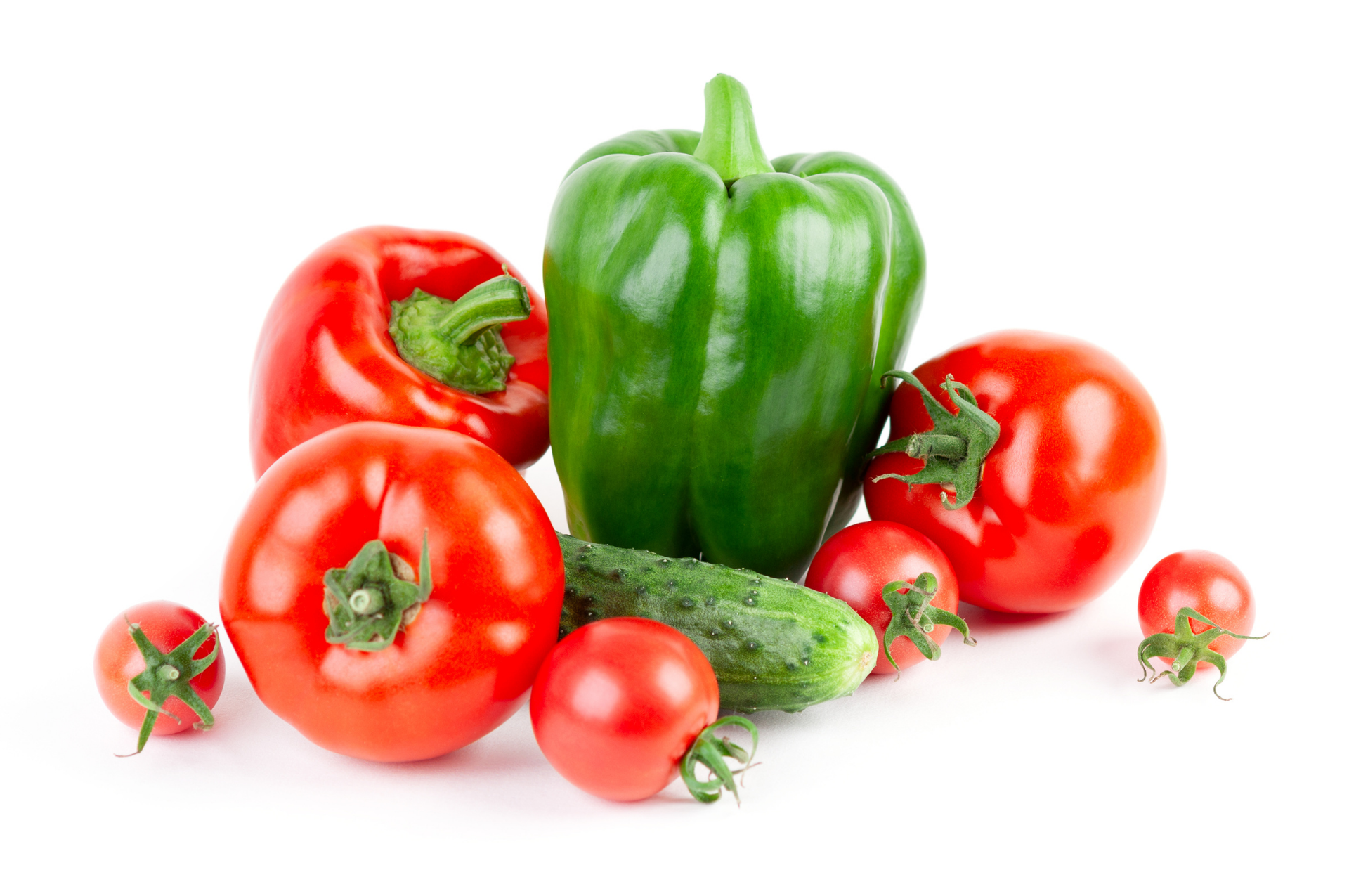 Assorted red and green peppers and tomatoes on a white background