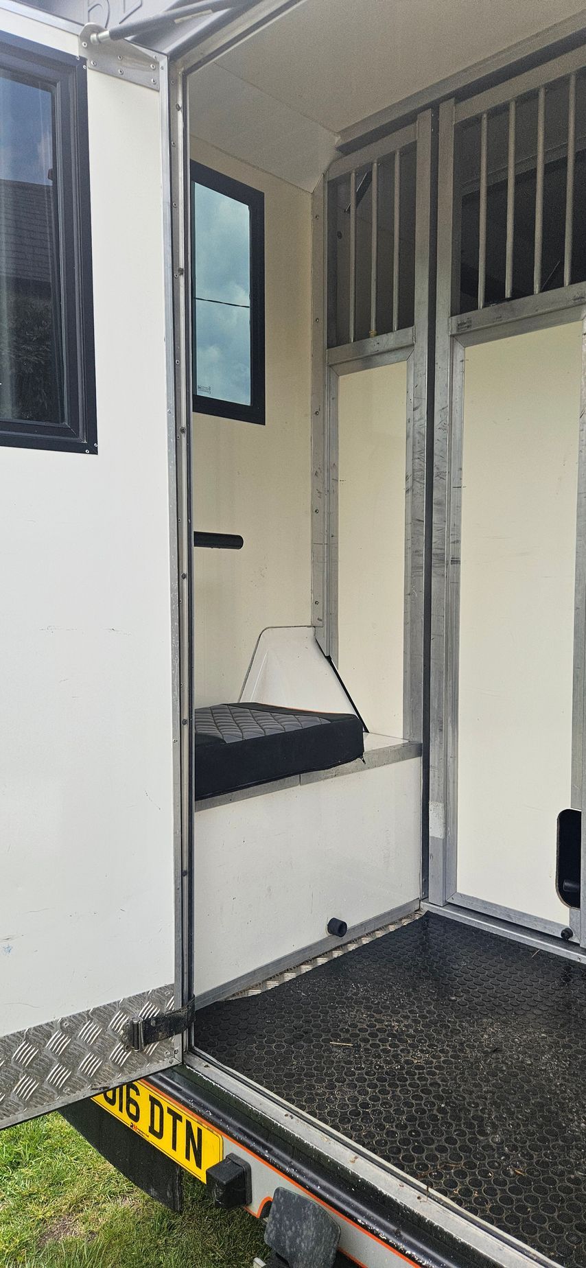Interior of an accessible vehicle with a wheelchair lift platform and open door.