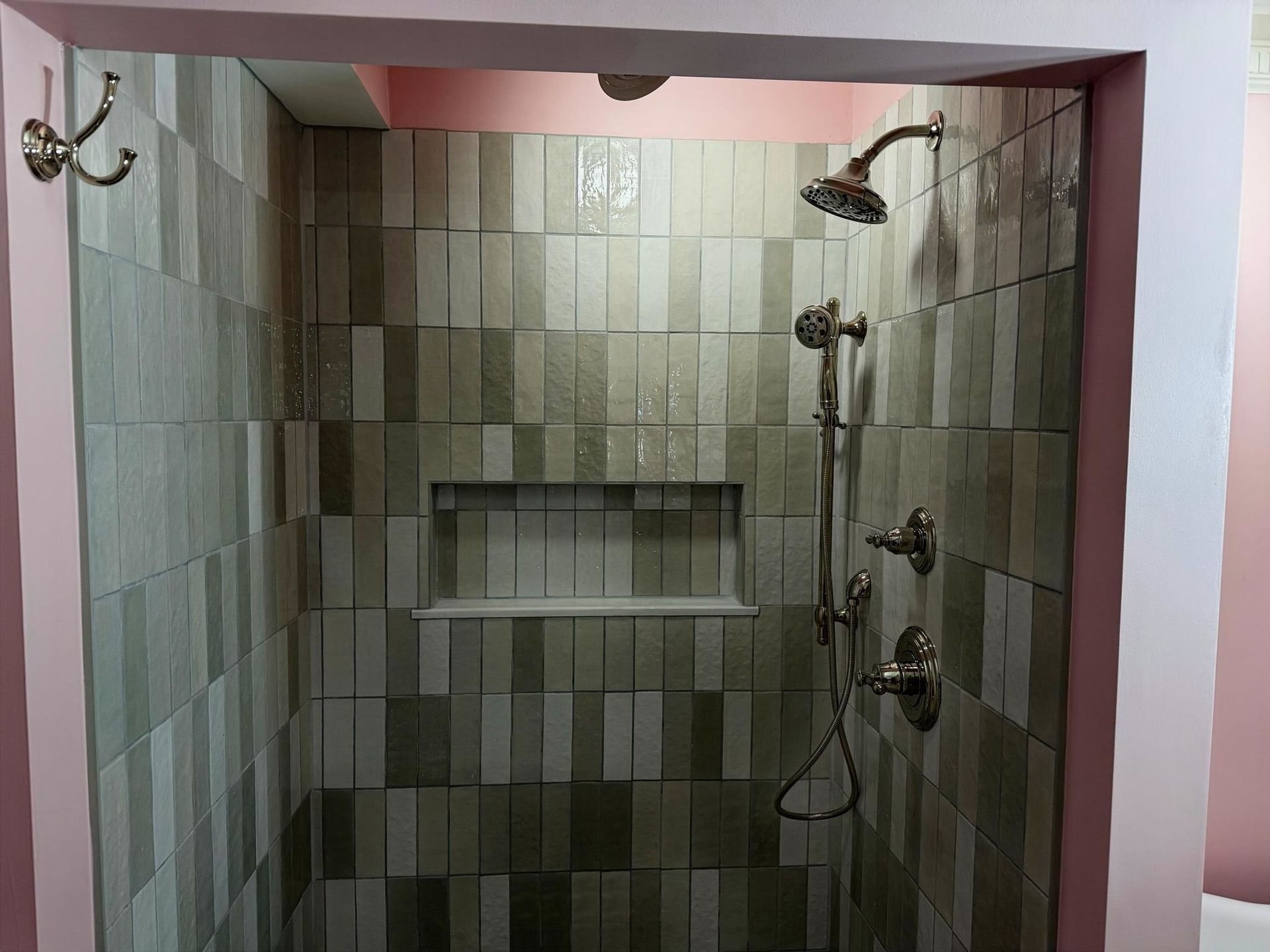 Tiled shower stall with recessed shelf, chrome fixtures, and two showerheads Tiled shower stall with recessed shelf, chrome fixtures, and two showerheads
