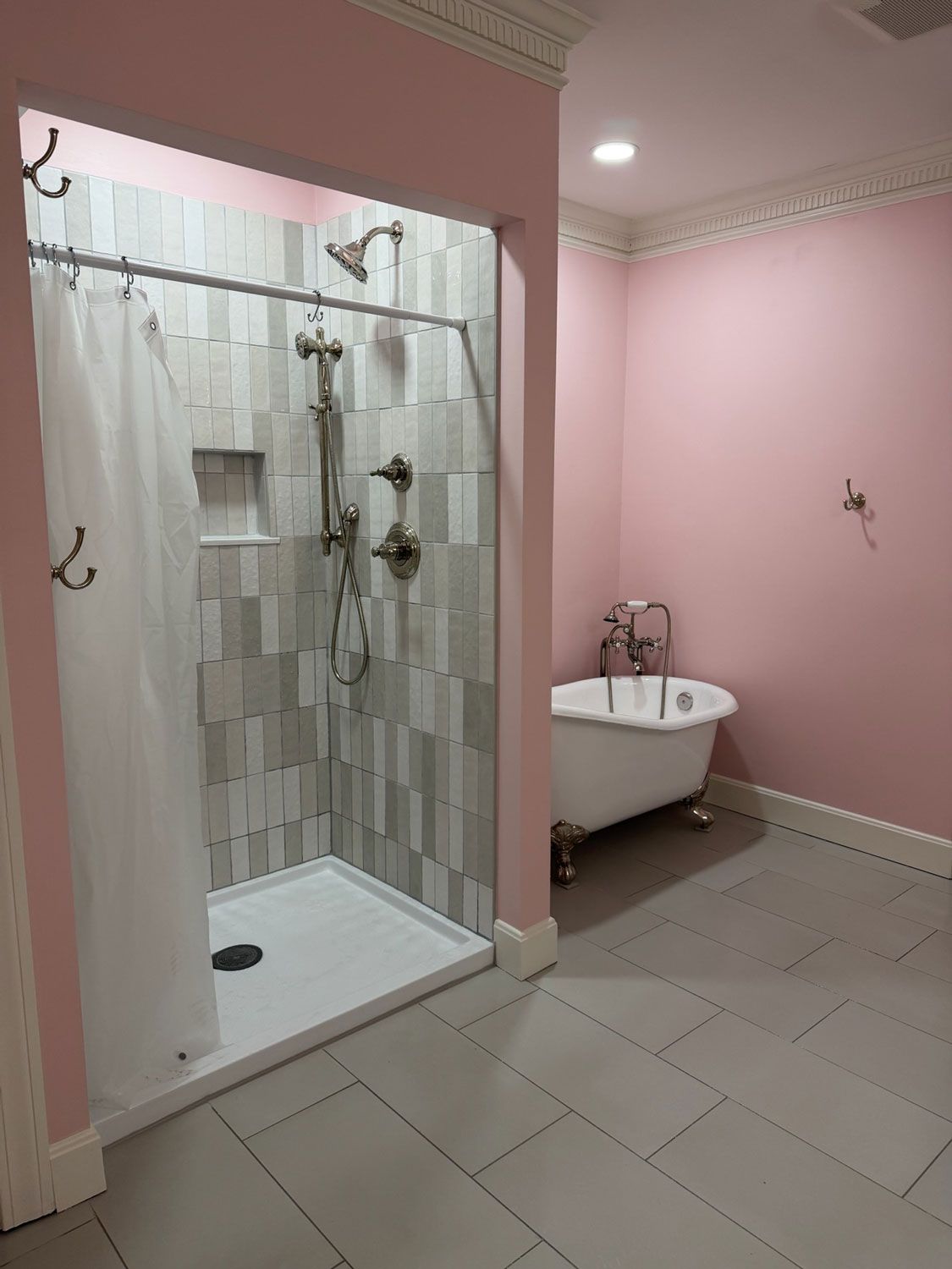 Pink bathroom with tiled floor, walk-in shower, and white clawfoot tub. Pink bathroom with tiled floor, walk-in shower, and white clawfoot tub.
