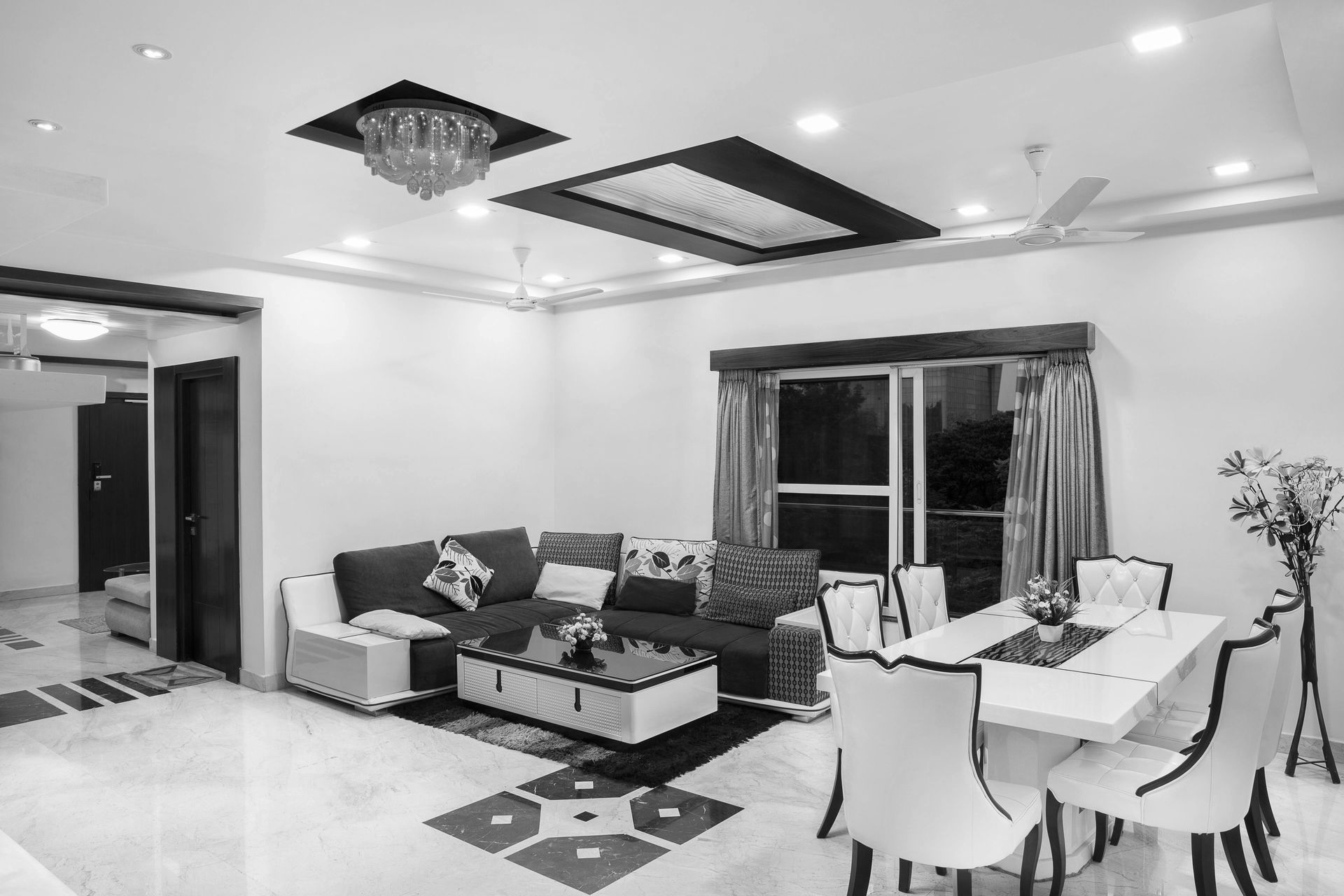 Living room with a sectional sofa, dining area, and ornate ceiling lighting.