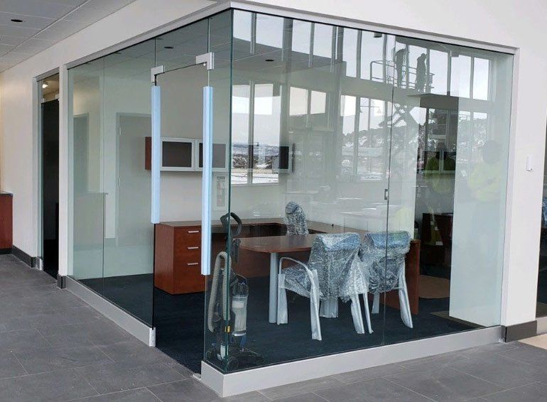 Office space with glass walls, and glass door by Sun Glass
