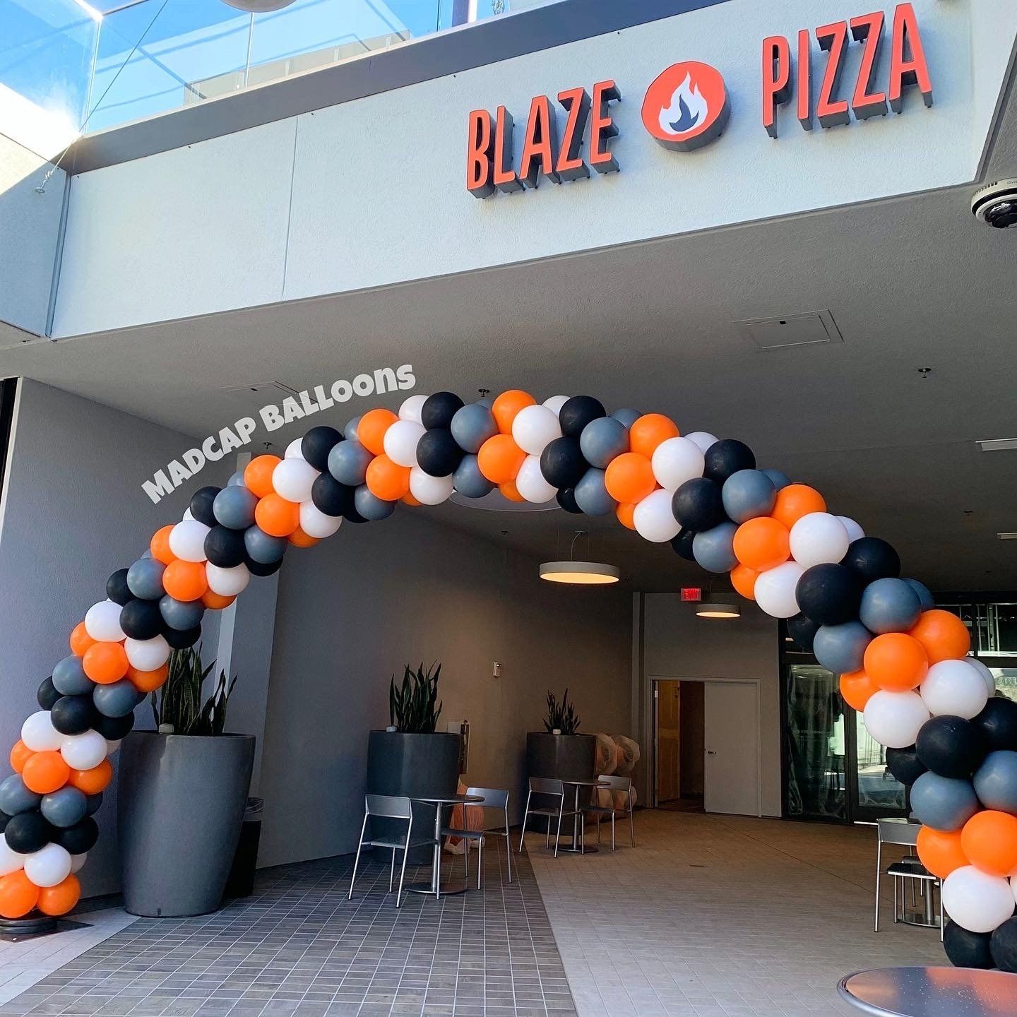 orange, black, and white corporate balloon arch