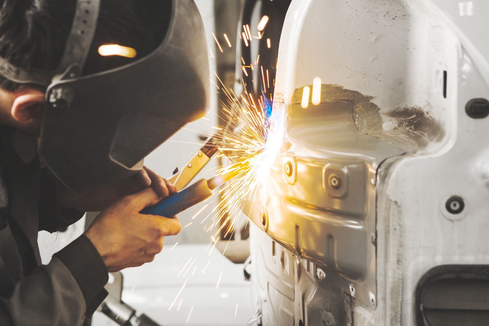 A man is welding a RV in a garage.