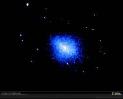 A vivid blue cosmic cloud glows surrounded by small white stars. 