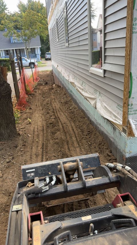 A ladder is sitting in front of a house under construction.