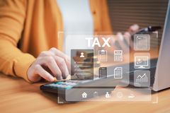 Person using a tablet with a tax interface overlay on a desk