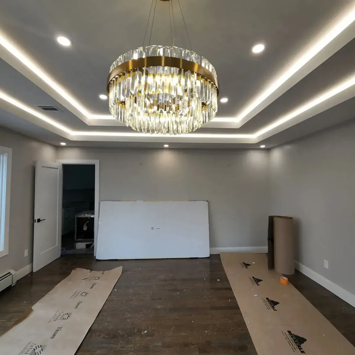 An empty room with a large chandelier hanging from the ceiling