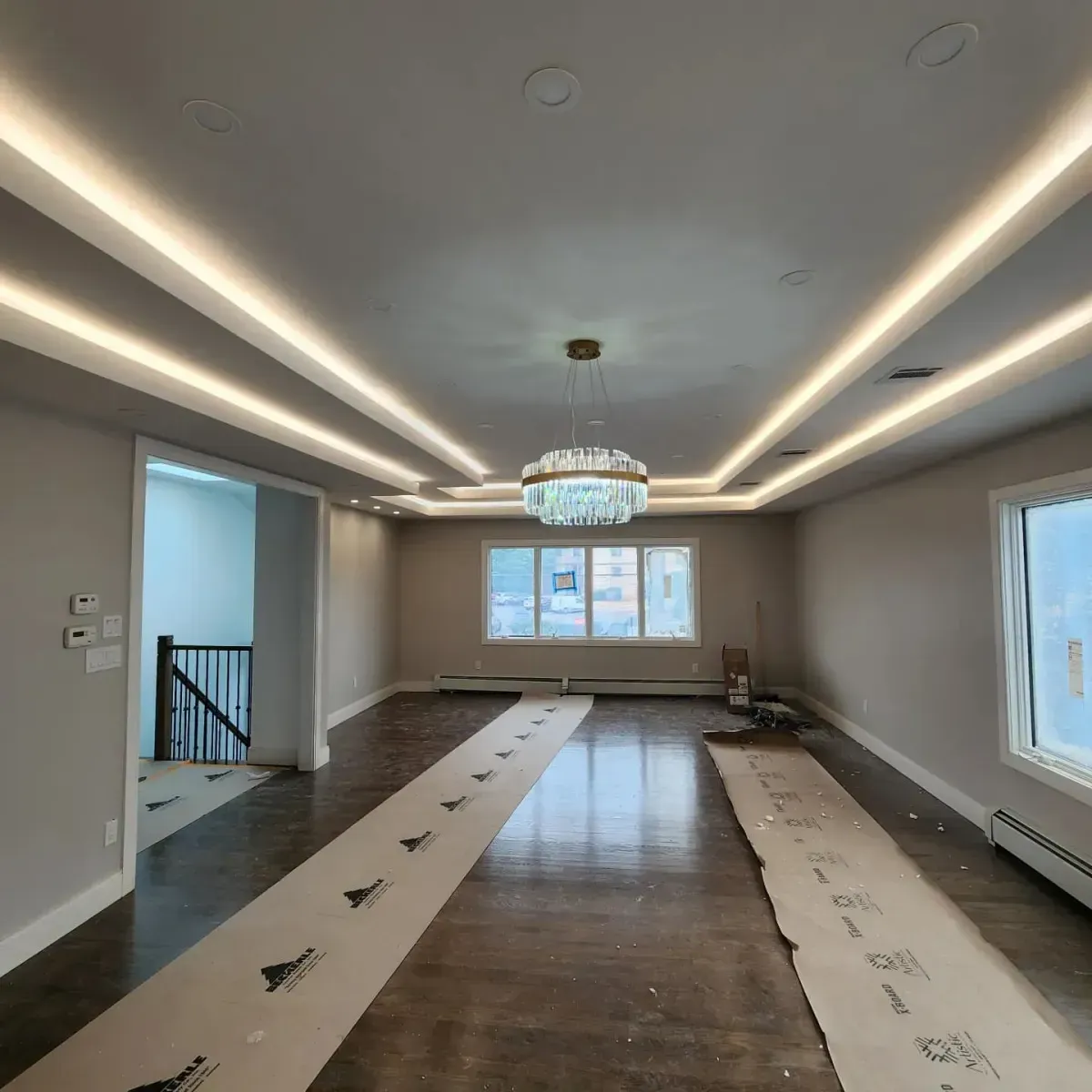 A large empty room with a chandelier hanging from the ceiling