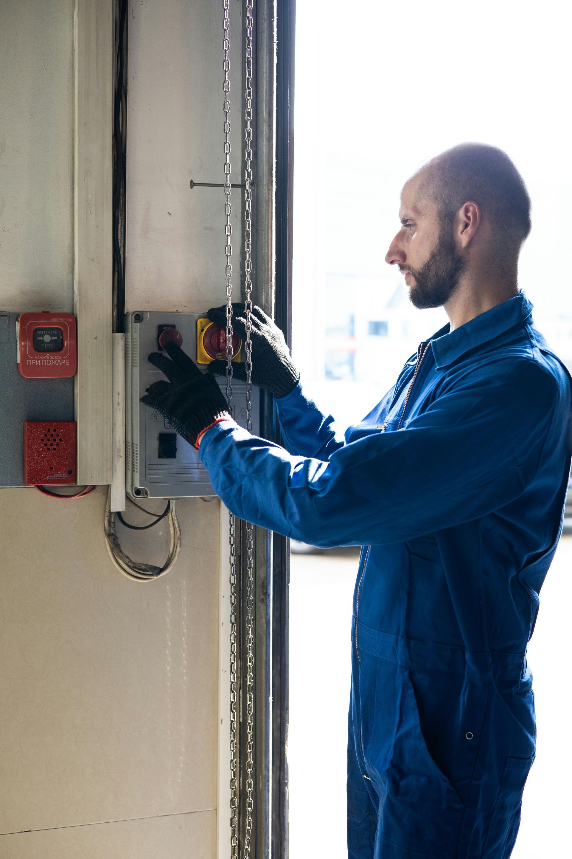 A man wearing a platinum electric shirt is working on an electrical box.