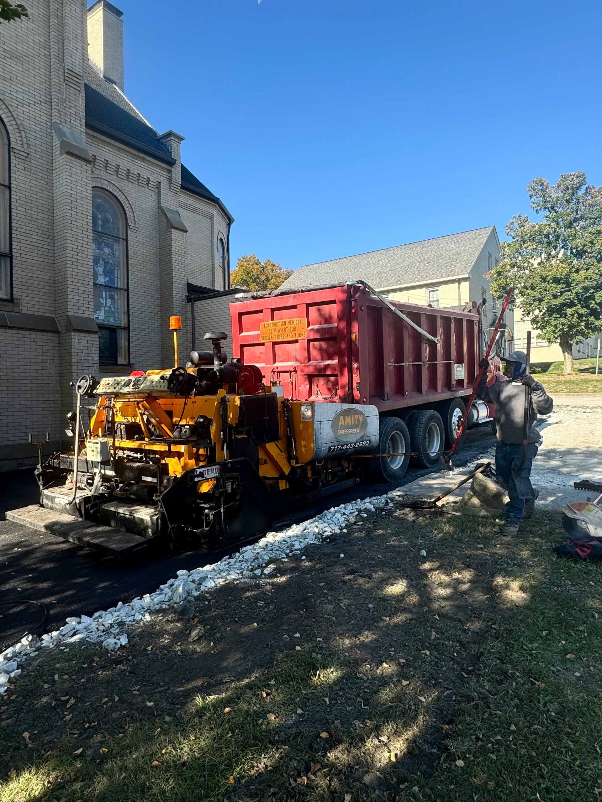 A red dump truck is parked in front of a building.