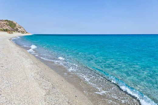 Una spiaggia sabbiosa accanto a un grande specchio d'acqua.
