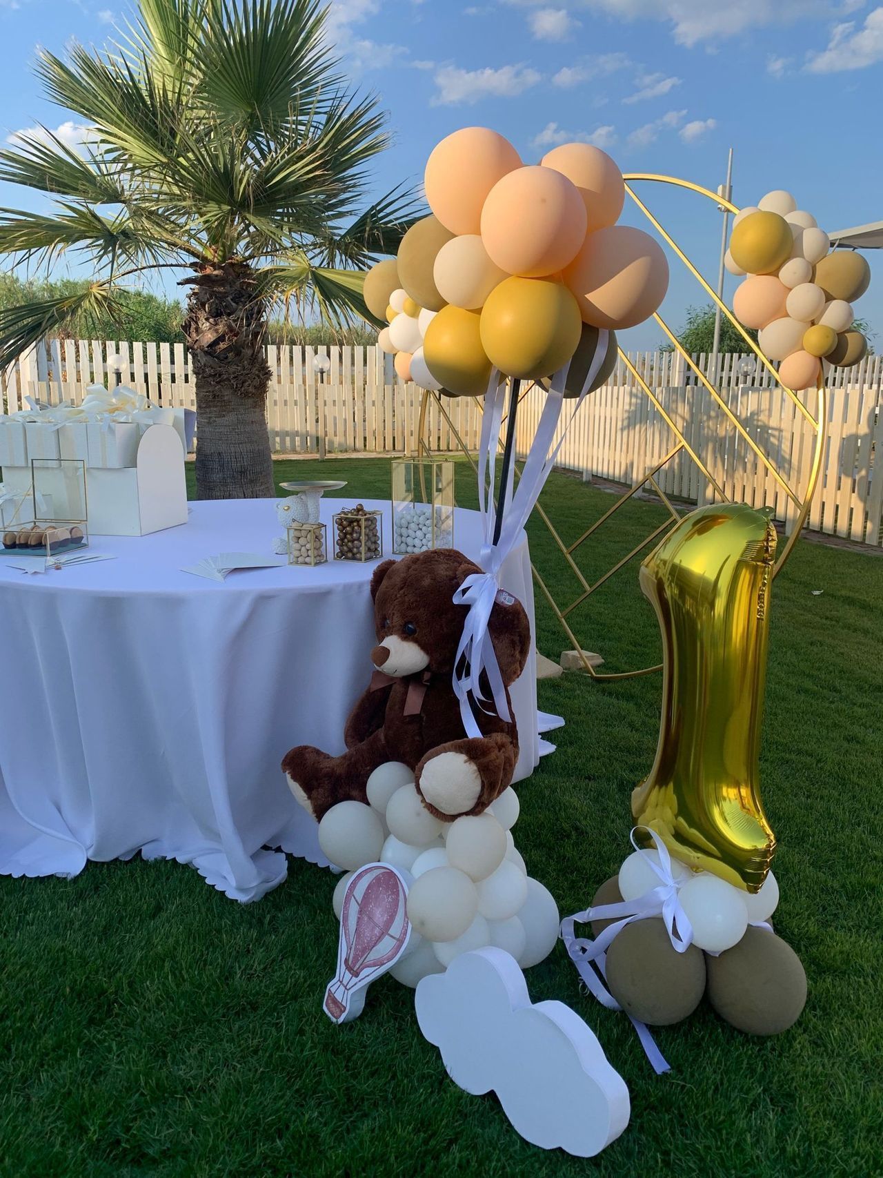 Un tavolo con palloncini e sopra un orsacchiotto